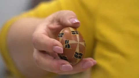 A hand holds a traditional Hungarian Easter egg with geometric wax patterns Stock Footage 307187635