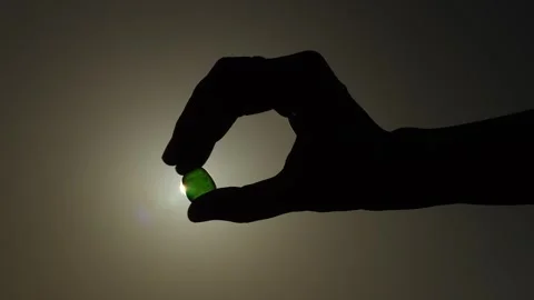 Hand holds a transparent stone in backlight Stock Footage 278268048