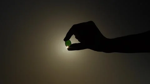 Hand holds a transparent stone in backlight Stock Footage 278902835
