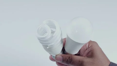 Hand Holds Two White Led And Cfl Bulbs Vídeo Stock 248685666