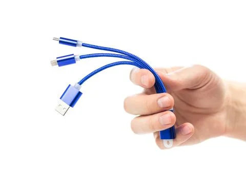 The hand holds a universal USB cable. Close up. On a white background 库存照片