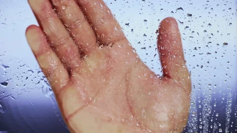 Hand holds on the wet window after a rain. Blurred background. Close up Stock Footage 121892119