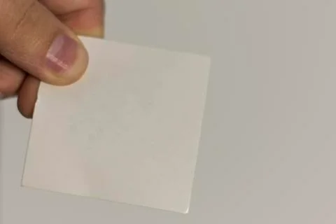 The hand holds a white card for events. Isolated object with white background Stock Photos