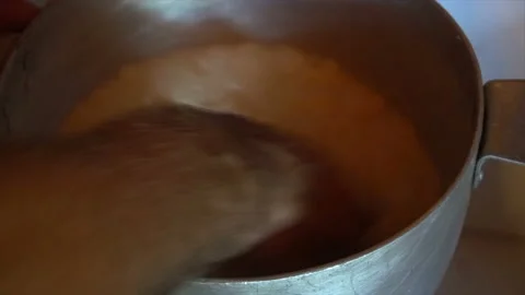 Hand in hot fermented sheep's milk collects large lump of cheese in a wooden Stock Footage 94238656