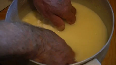 Hand in hot fermented sheep's milk collects large lump of cheese in a wooden 스톡 동영상 94239287