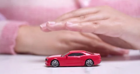 Hand hovering over a red toy sportscar, manifesting the desire to own a Vídeo Stock 261165758