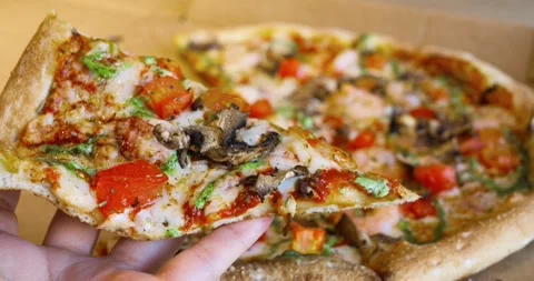Hand hovering over whole pizza in cardboard box, lifting slice showcasing melted Stock Footage 309048077