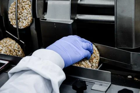 Hand of a human in glove works on conveyor. automatic line for the production Stock Photos