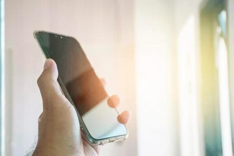 Hand of human using smartphone with a blank black screen. Stock Photos