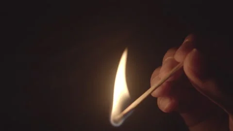 Hand Igniting Matchstick Creating Bright Flame Spark in Darkness 库存影片 334644054