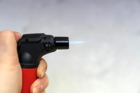 The hand includes a lighter. The fire is on. Stock Photos