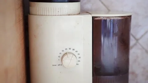 The hand includes an old electric coffee grinder, a container 库存影片 155808113