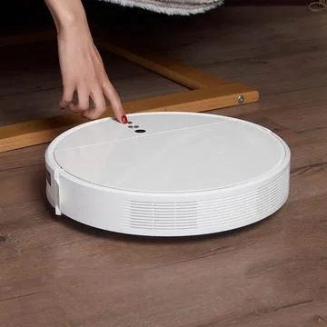 Hand includes a robot vacuum cleaner on the floor Stock Photos