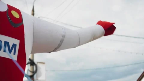 The hand of the inflatable figure moves to attract customers. Close up Stock Footage 131058018