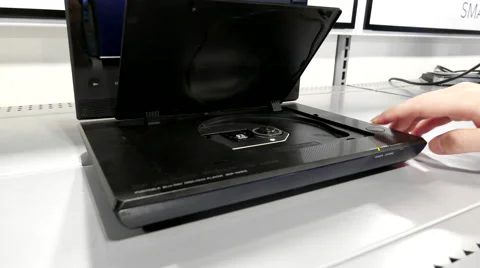 Hand insert and eject a dvd in a player inside store Stock Footage 65746495