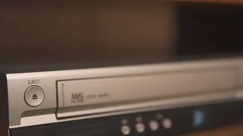 Hand insert and eject old VHS tape cassette from silver videorecorder Stock Footage 111261824
