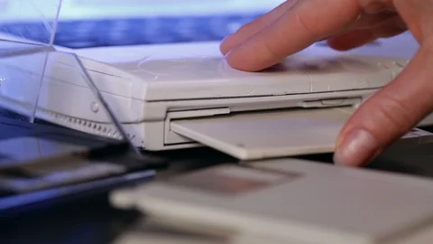 Hand insert floppy diskette into laptop computer Video stock 93932263