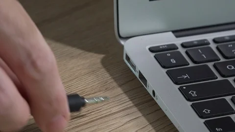 Hand inserting audio cable phone connector jack into laptop computer Stock Footage 128757284