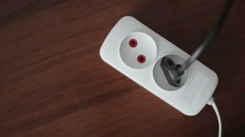 Hand inserting a black plug into white socket Stock Footage 101337600