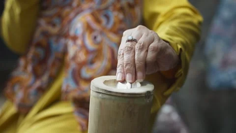 Hand Inserting Coin into Bamboo Piggy Bank Stock Footage 344236020