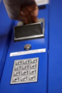 Hand inserting coin into vending machine Foto stock