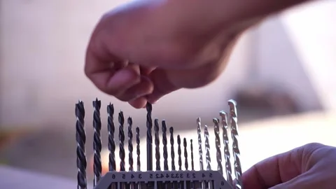 Hand inserting drill bit into organized case, various sizes drill bits, Stock Footage 345293566