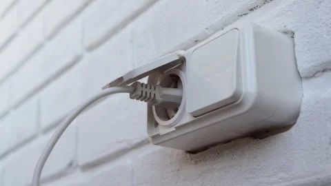 Hand inserting electrical plug into and plug out socket and on wall close up. Stock Footage 283924806