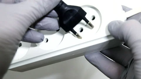 Hand Inserting European Plug into Power Extension Socket Stock-Footage 306731870