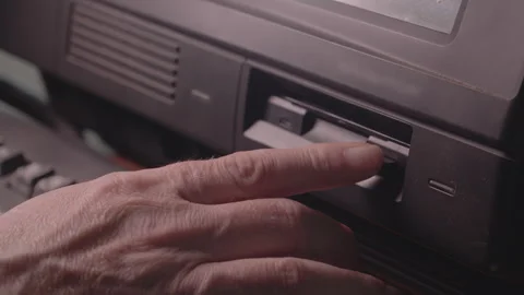Hand Inserting Floppy Disk into Retro Desktop Computer Stock Footage 348913305