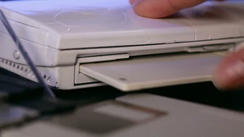 Hand inserting floppy diskette in old laptop computer Video stock 90645196