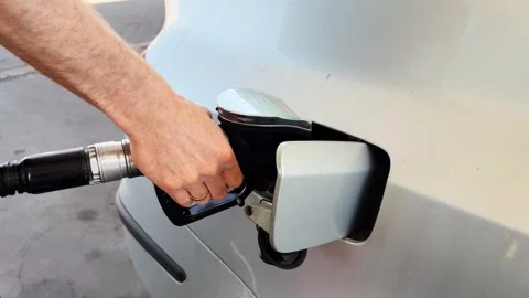 Hand inserting fuel nozzle into car gas tank close up. Stock Footage 335872990
