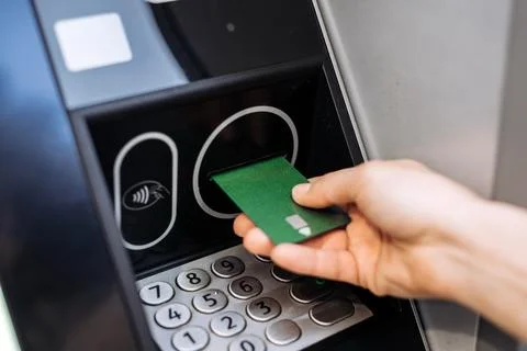 Hand inserting green card into ATM machine, showcasing modern banking techn.. Stock Photos