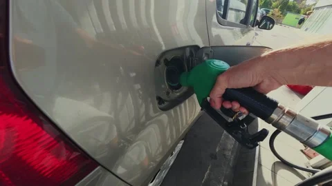 Hand Inserting Green Fuel Nozzle into Car Tank at Gas Station 動画素材 347058697