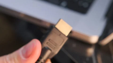 Hand inserting hdmi cable close-up shot into laptop port, device connection Stock Footage 333649421