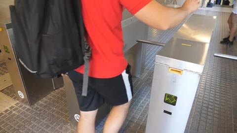 Hand inserting his paper ticket into slot of turnstile at underground. Tourist Stock Footage 306655536