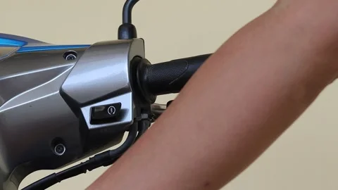 Hand is inserting the key and using button starting on motorcycle Stock Footage 145896411