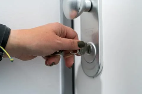 Hand inserting key into door lock close up security concept Stock Photos