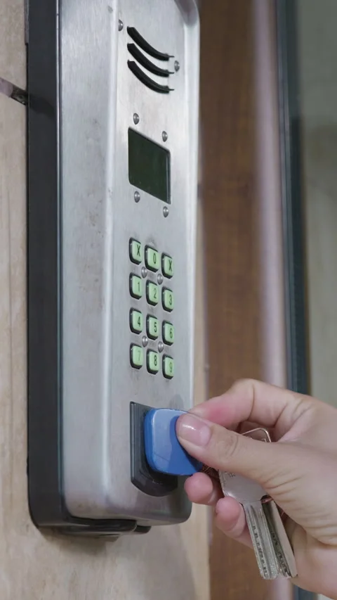 Hand inserting keycard into electronic access control panel with illuminated Stock Footage 341439382