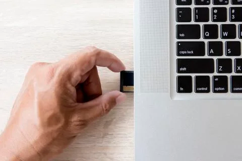 Hand inserting memory card into laptop slot Stock Photos