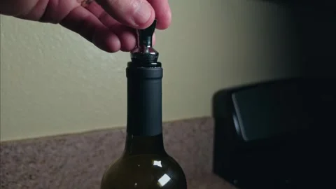 Hand inserting a metal stopper into a wine bottle Stock-Footage 330068169
