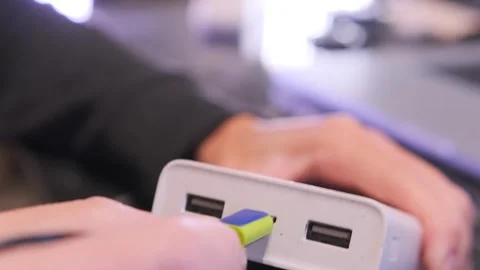 Hand inserting micro usb cable close-up shot into power bank port, device Stock Footage 333649407