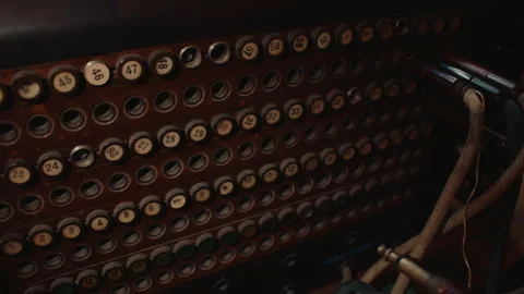 Hand inserting patch cable into vintage telephone switchboard during manual time Stock Footage 340490518