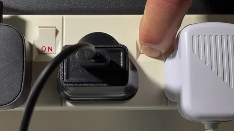 A hand inserting a plug into an extension board then switching the power on. Stock Footage 251151180