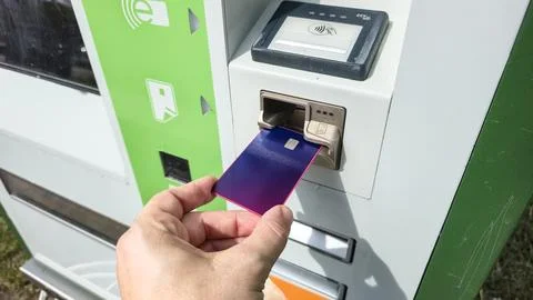 Hand inserting purple payment card into reader, electronic transaction, kiosk Stock Photos