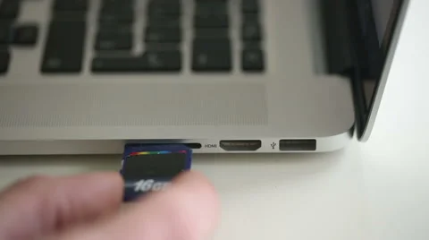 Hand inserting SD card 16Gb in memory card reader of notebook Stock Footage 47746059