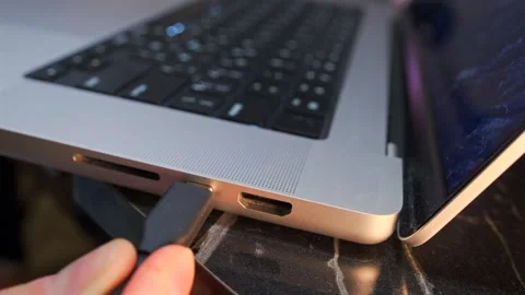 Hand inserting usb-c cable close-up shot into laptop port, device connection Stock Footage 333649436