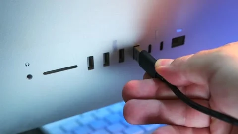 Hand inserting usb cable close-up view, plugging connector into computer port on Stock Footage 333649042