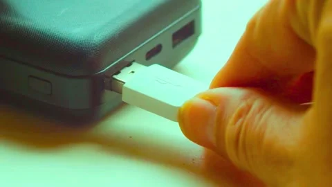 Hand inserting usb cable into power bank portable battery charging device Stock-Footage 341802056