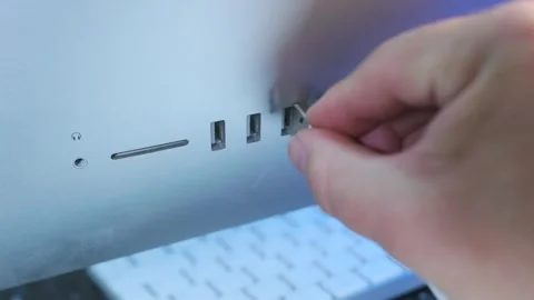 Hand inserting usb cables close-up shot into computer ports on all-in-one Stock Footage 333649089