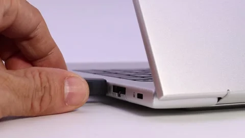 Hand inserting usb flash drive into laptop port for data storage Stock Footage 329010057